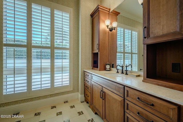 bathroom featuring baseboards, plenty of natural light, vanity, and wallpapered walls