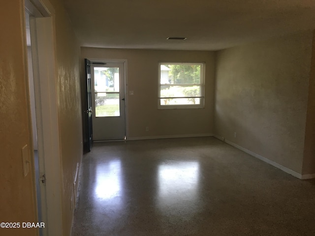 empty room with a healthy amount of sunlight and concrete floors