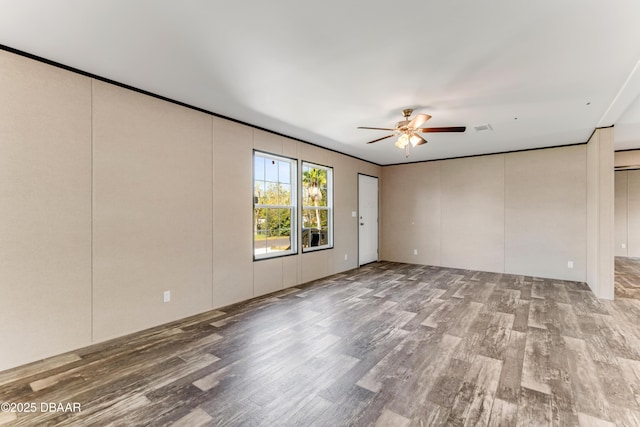 empty room with visible vents, wood finished floors, and a ceiling fan