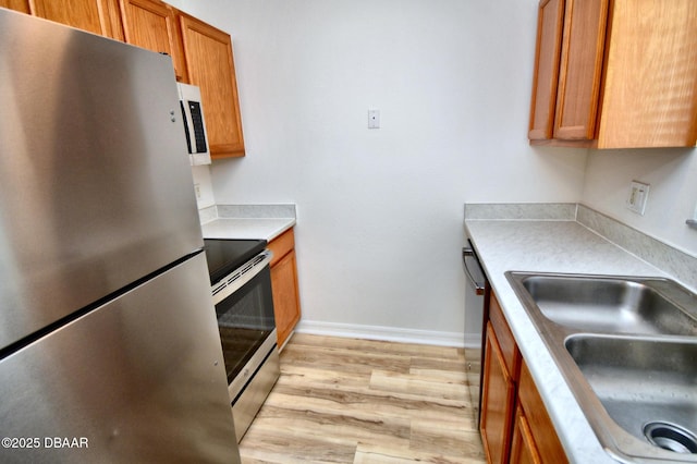 kitchen featuring sink, light hardwood / wood-style flooring, and appliances with stainless steel finishes