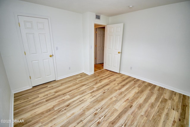 unfurnished bedroom featuring a closet and light wood-type flooring