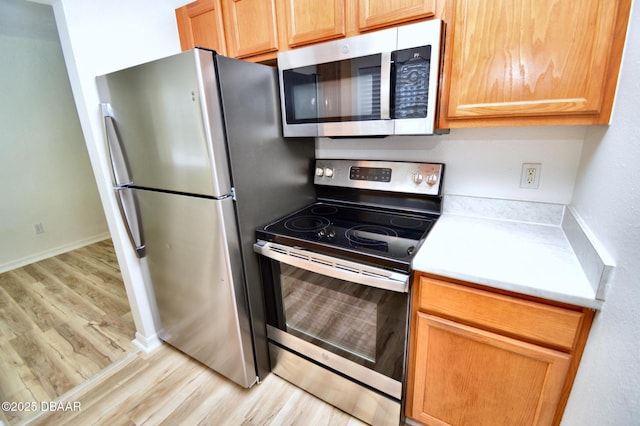 kitchen featuring stainless steel appliances and light hardwood / wood-style flooring