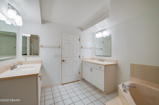 bathroom featuring a garden tub, two vanities, a sink, and tile patterned floors