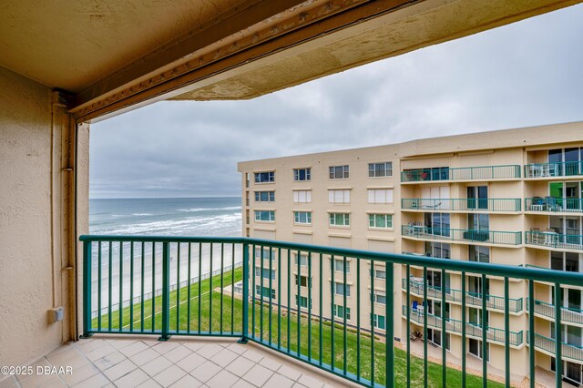 balcony with a water view and a beach view