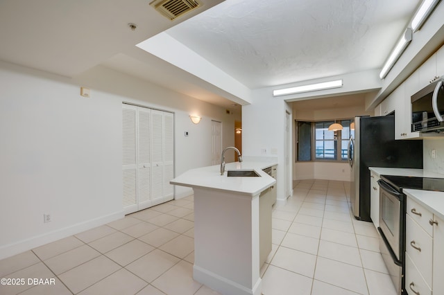 kitchen with light countertops, visible vents, appliances with stainless steel finishes, white cabinetry, and a sink