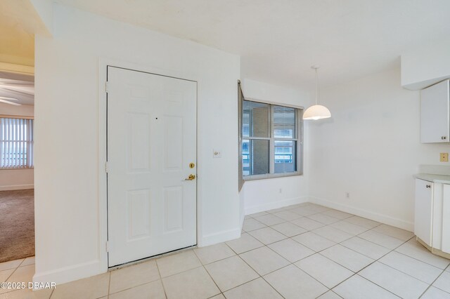 foyer featuring baseboards and light tile patterned floors