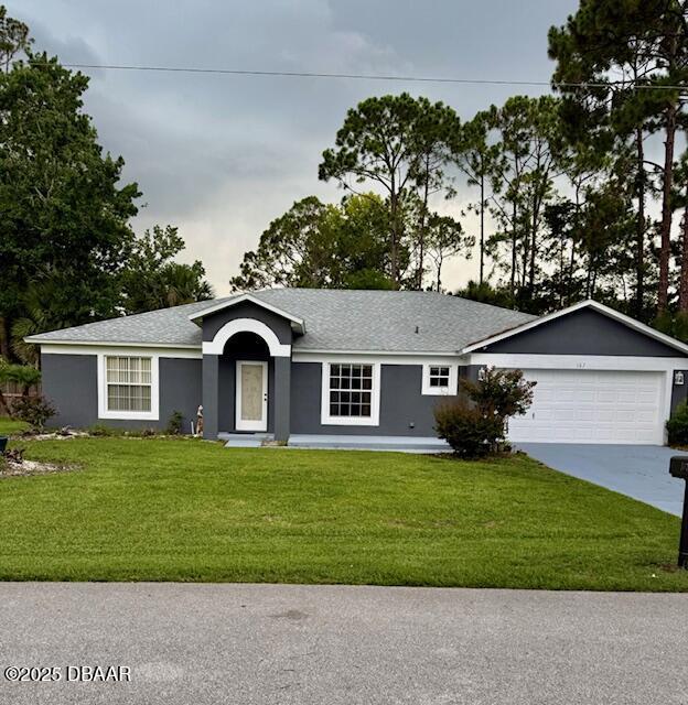 107 Beacon Mill Ln, Palm Coast, FL 32137 - ranch-style house featuring stucco siding, a front lawn, concrete driveway, an attached garage, and a shingled roof