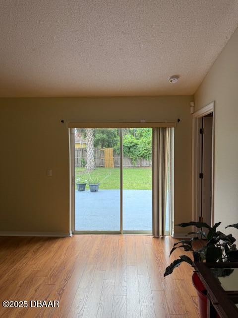 107 Beacon Mill Ln, Palm Coast, FL 32137 - doorway to outside featuring light wood-style flooring and a textured ceiling