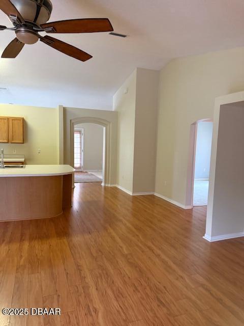 107 Beacon Mill Ln, Palm Coast, FL 32137 - unfurnished living room with arched walkways, light wood-style flooring, and ceiling fan