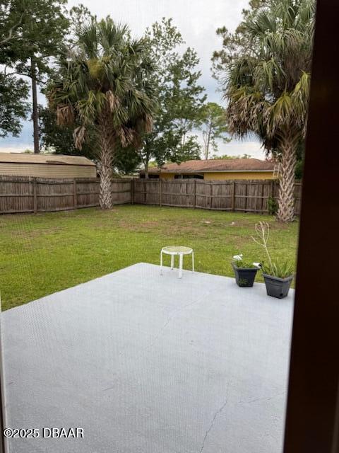 107 Beacon Mill Ln, Palm Coast, FL 32137 - fenced backyard with a patio area