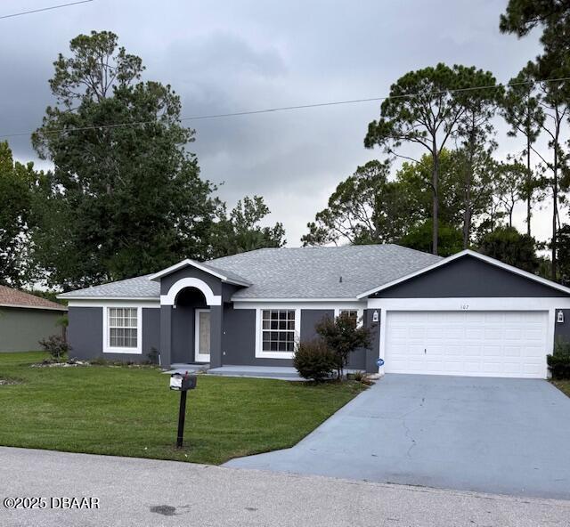 107 Beacon Mill Ln, Palm Coast, FL 32137 - ranch-style house with a front lawn, concrete driveway, a garage, stucco siding, and roof with shingles