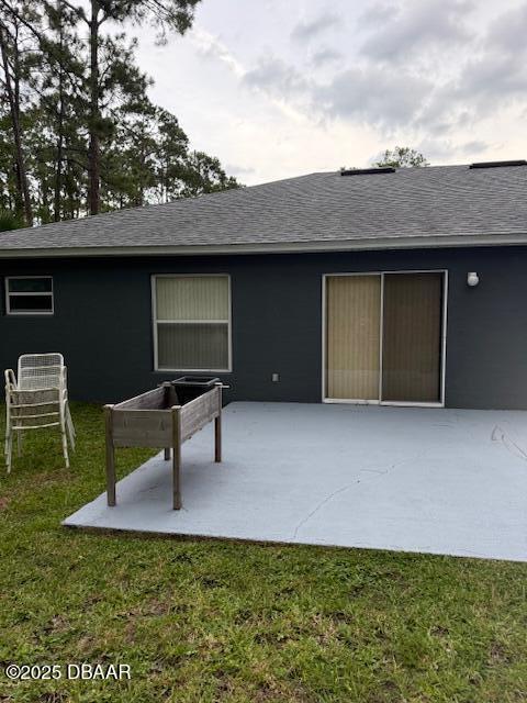 107 Beacon Mill Ln, Palm Coast, FL 32137 - back of property with a patio area, a shingled roof, and a yard