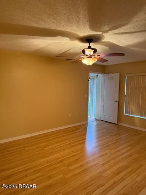 107 Beacon Mill Ln, Palm Coast, FL 32137 - spare room with a textured ceiling, ceiling fan, and light wood-style floors