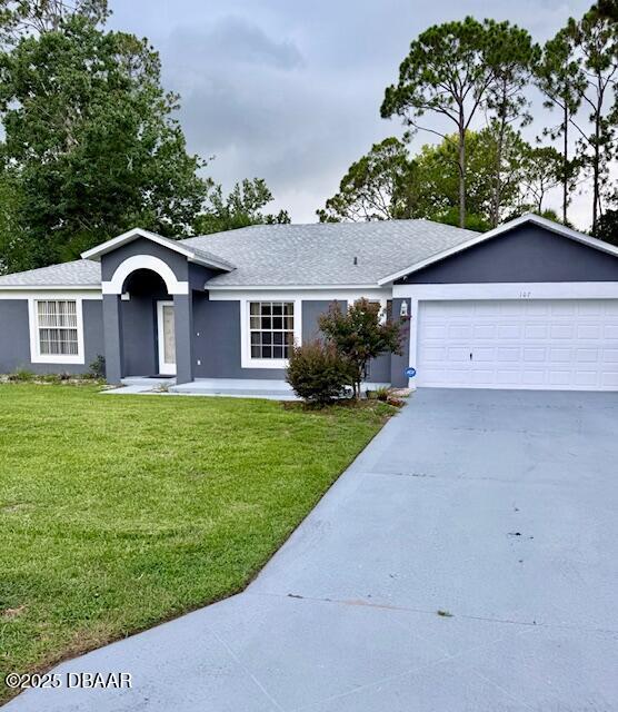 107 Beacon Mill Ln, Palm Coast, FL 32137 - single story home featuring driveway, a front yard, an attached garage, stucco siding, and roof with shingles