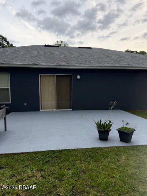 107 Beacon Mill Ln, Palm Coast, FL 32137 - rear view of property with a patio area, a shingled roof, and a yard