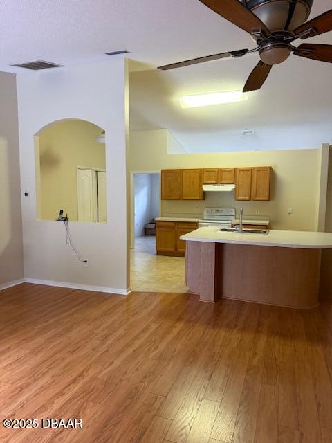 107 Beacon Mill Ln, Palm Coast, FL 32137 - kitchen featuring stove, light countertops, ceiling fan, under cabinet range hood, and light wood-style flooring