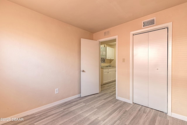 unfurnished bedroom with light wood-type flooring, baseboards, and visible vents