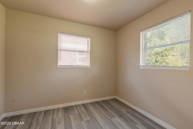 empty room with baseboards and wood finished floors