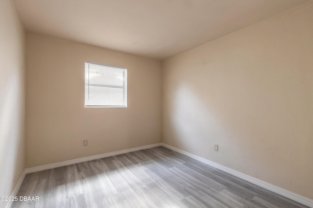 unfurnished room featuring baseboards and wood finished floors