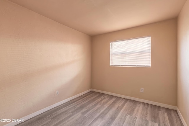 unfurnished room with light wood-style flooring and baseboards