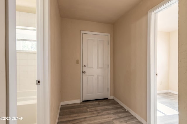 hallway with baseboards and wood finished floors