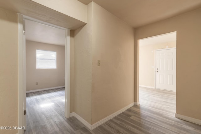 hallway featuring baseboards and wood finished floors