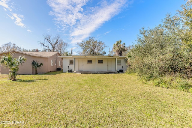 back of house with central AC and a lawn