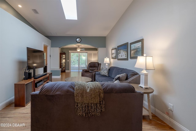 living room featuring light wood-type flooring, ceiling fan, and vaulted ceiling