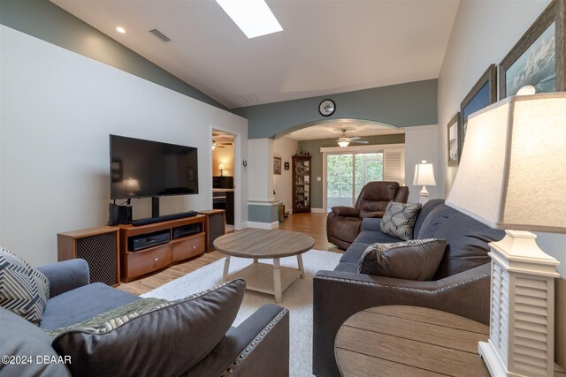 living room with hardwood / wood-style floors, ceiling fan, and vaulted ceiling