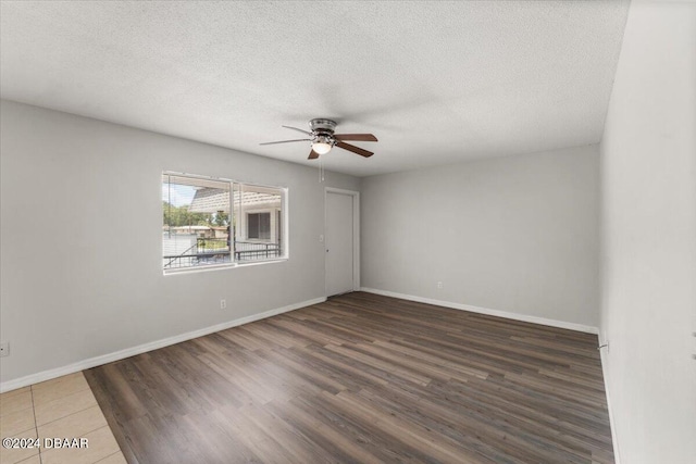 unfurnished room with ceiling fan, baseboards, a textured ceiling, and wood finished floors