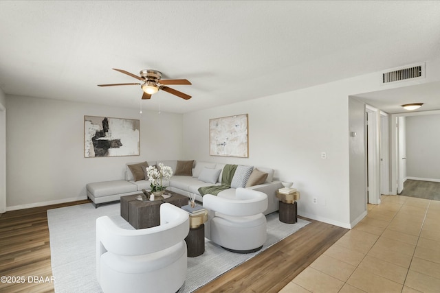 living area with baseboards, visible vents, and light wood finished floors