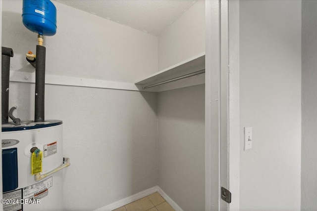 spacious closet with electric water heater and light tile patterned floors