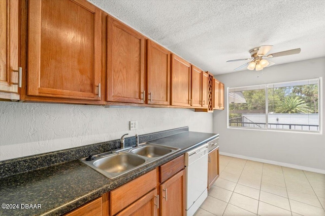 kitchen with sink, white dishwasher, ceiling fan, a textured ceiling, and light tile patterned floors