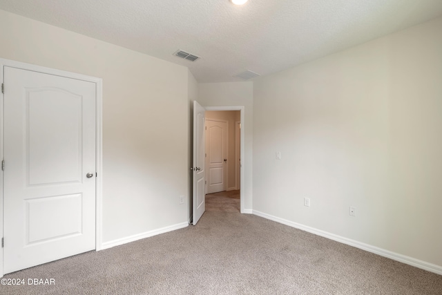 unfurnished bedroom featuring carpet and a textured ceiling