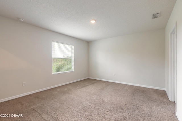 spare room featuring a textured ceiling and carpet floors