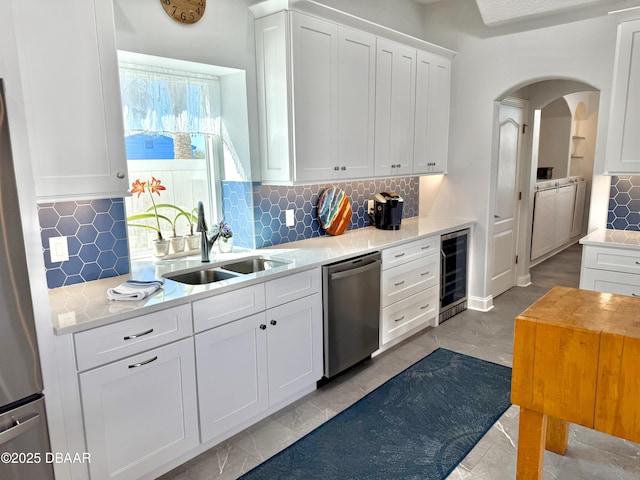 1811 N Central Ave, Flagler Beach, FL 32136 - kitchen featuring white cabinets, appliances with stainless steel finishes, a sink, tasteful backsplash, and wine cooler
