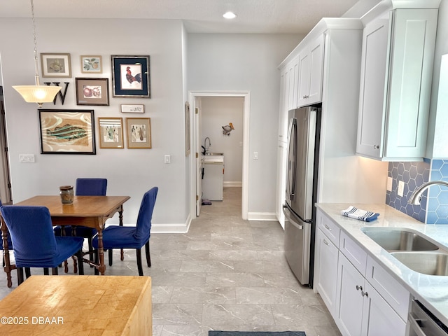 1811 N Central Ave, Flagler Beach, FL 32136 - kitchen featuring decorative backsplash, baseboards, white cabinetry, a sink, and appliances with stainless steel finishes
