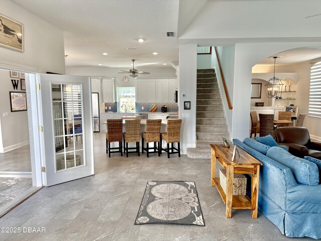 1811 N Central Ave, Flagler Beach, FL 32136 - living room with visible vents, stairway, recessed lighting, arched walkways, and ceiling fan with notable chandelier