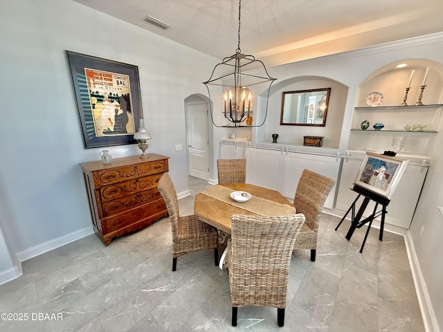 1811 N Central Ave, Flagler Beach, FL 32136 - dining area featuring visible vents, built in features, baseboards, a textured ceiling, and a notable chandelier