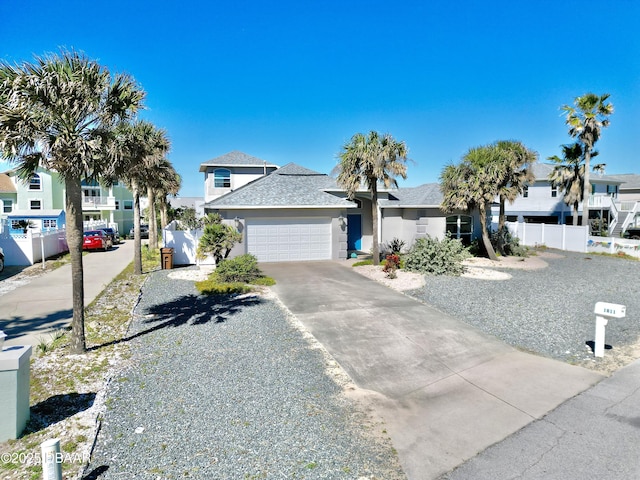 1811 N Central Ave, Flagler Beach, FL 32136 - view of front of home featuring a garage, fence, stucco siding, driveway, and a residential view