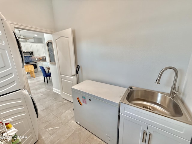 1811 N Central Ave, Flagler Beach, FL 32136 - laundry area featuring a sink, cabinet space, and stacked washer and dryer