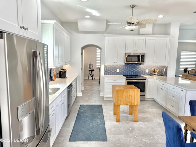 1811 N Central Ave, Flagler Beach, FL 32136 - kitchen with a ceiling fan, appliances with stainless steel finishes, tasteful backsplash, arched walkways, and light countertops