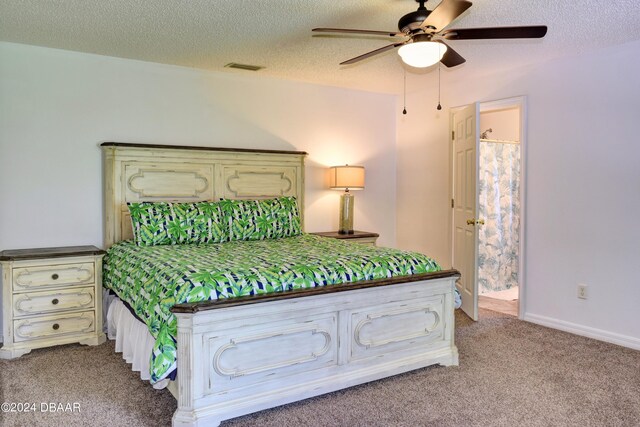 unfurnished bedroom featuring connected bathroom, a textured ceiling, light colored carpet, and ceiling fan