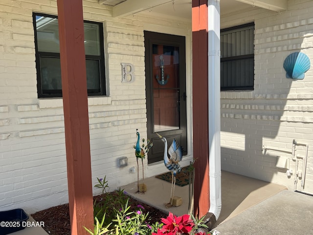 entrance to property featuring brick siding