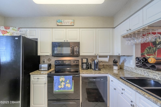 kitchen with backsplash, white cabinetry, and black appliances