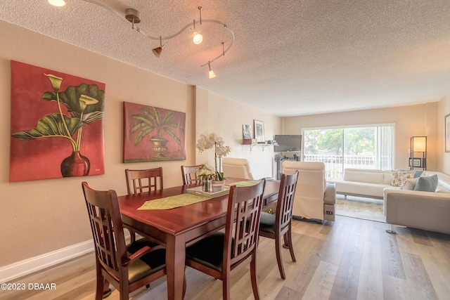 dining room featuring a textured ceiling and light hardwood / wood-style floors