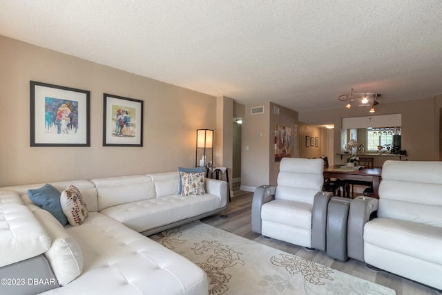 living room featuring a textured ceiling and light hardwood / wood-style flooring