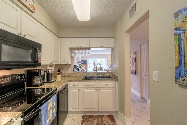 kitchen featuring white cabinets, black appliances, a textured ceiling, sink, and light tile patterned floors