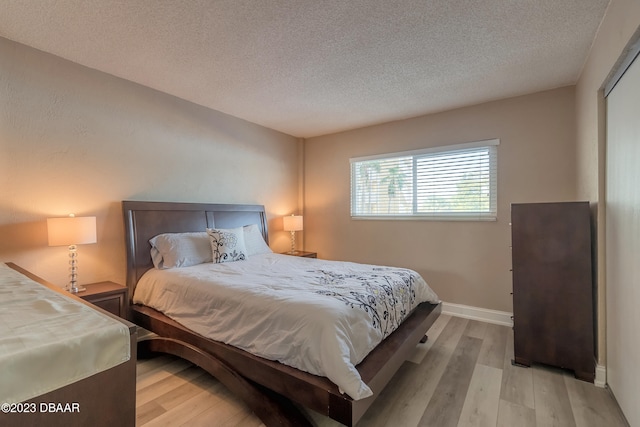 bedroom featuring light wood-type flooring and a textured ceiling