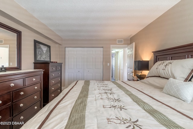 bedroom with a textured ceiling and a closet